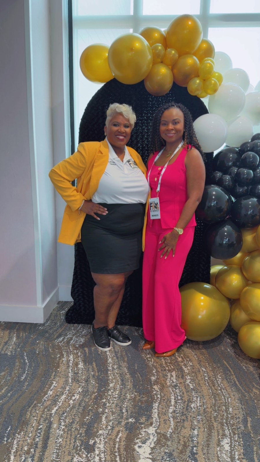 Toya and a member in a pink outfit posing together at a community gathering