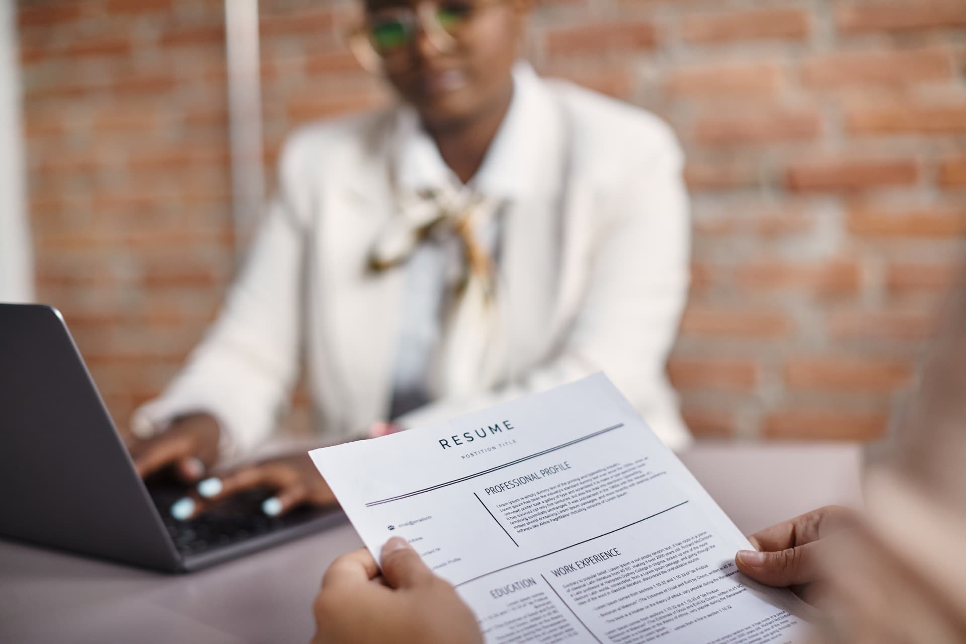 A professional reviewing a printed résumé in a modern office